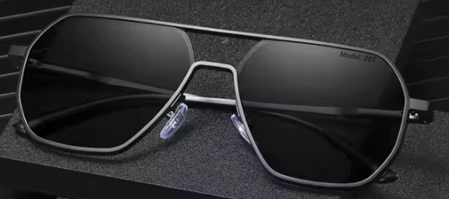Phos bold black photochromic sunglasses, folded and placed on a dark, stylish background.