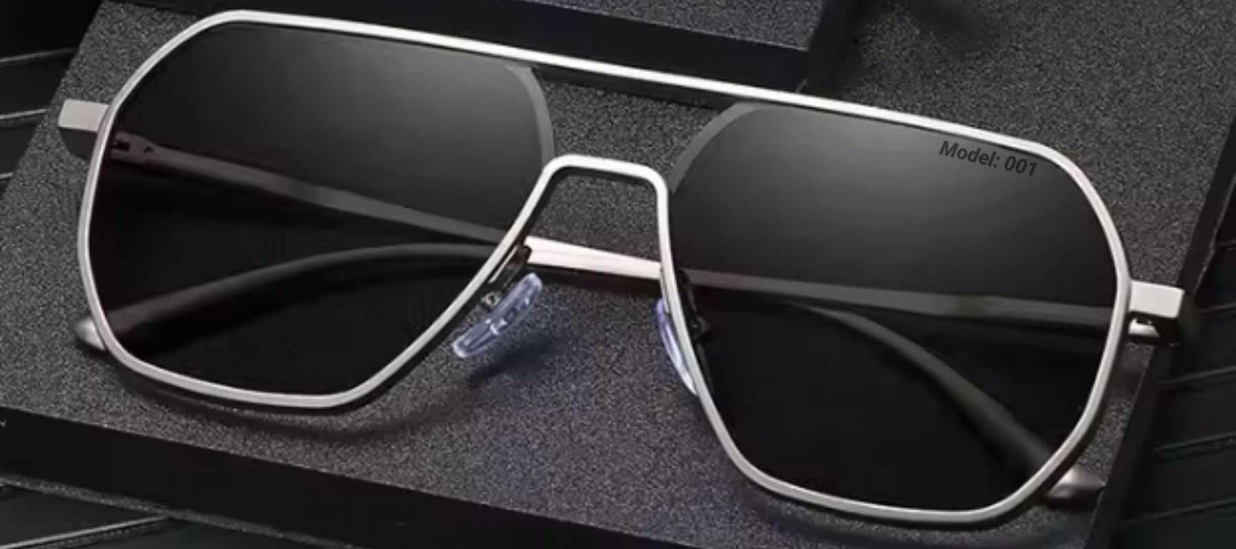 Phos gunmetal gray photochromic sunglasses, folded and resting on a dark, stylish background.
